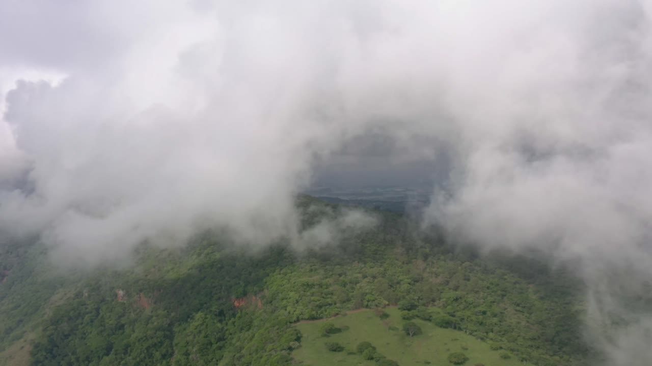 Clouds drifting across a green mountain landscape